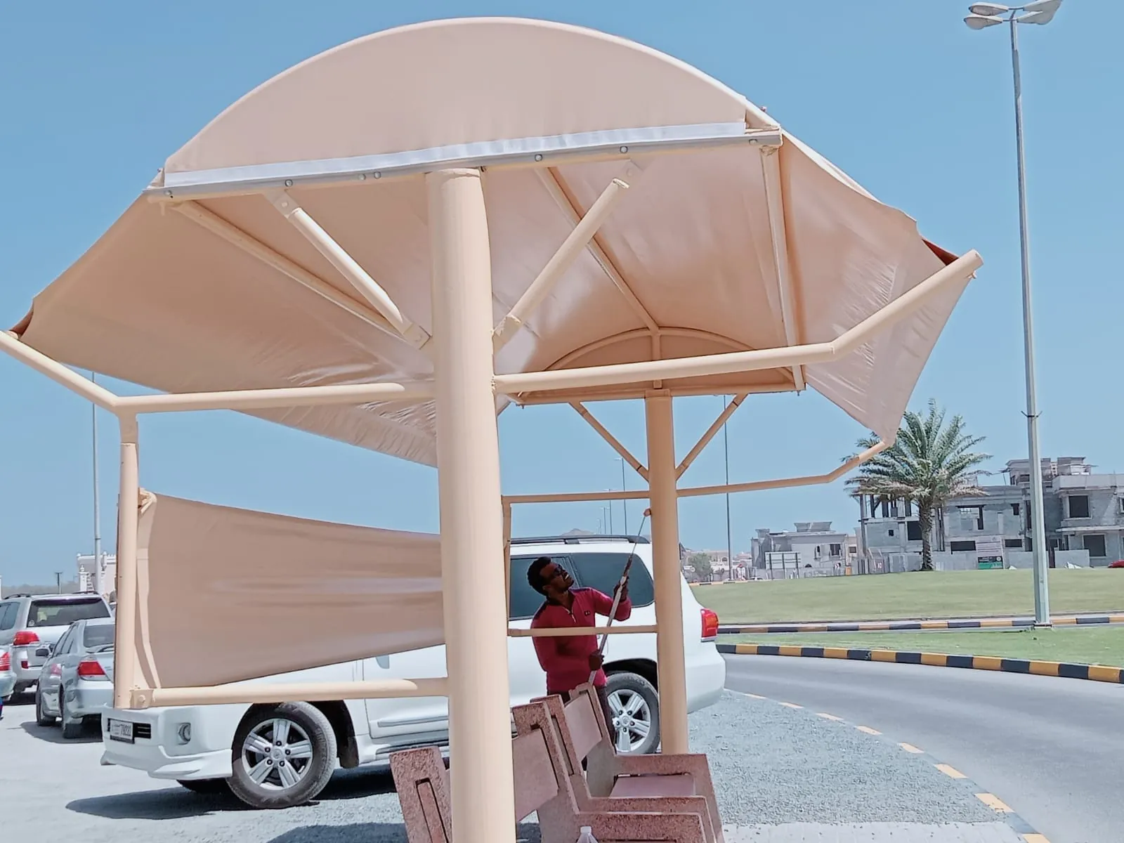 Our crew fitting PVC fabric on a bus shelter shade in the UAE